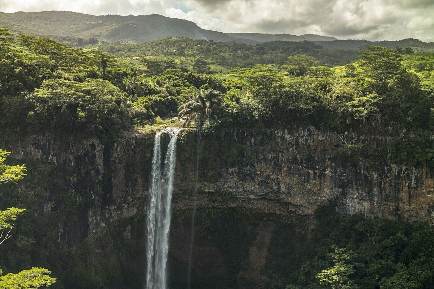 A waterfall dropping into a forested gorge in the Mauritian interior